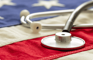 Stethoscope on American flag with red, white, and blue colors.